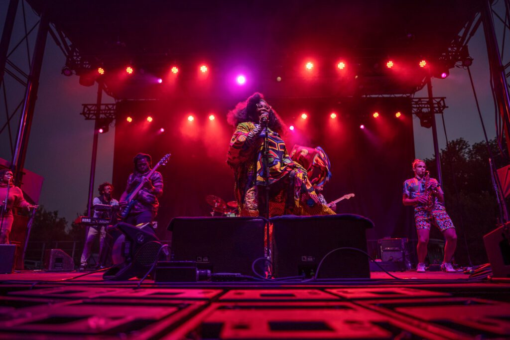 Tank and the Bangas wearing colorful outfits on stage