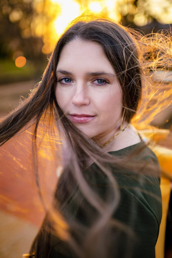 Mizzou College Senior girl hair blowing in wind with warm sun light glowing